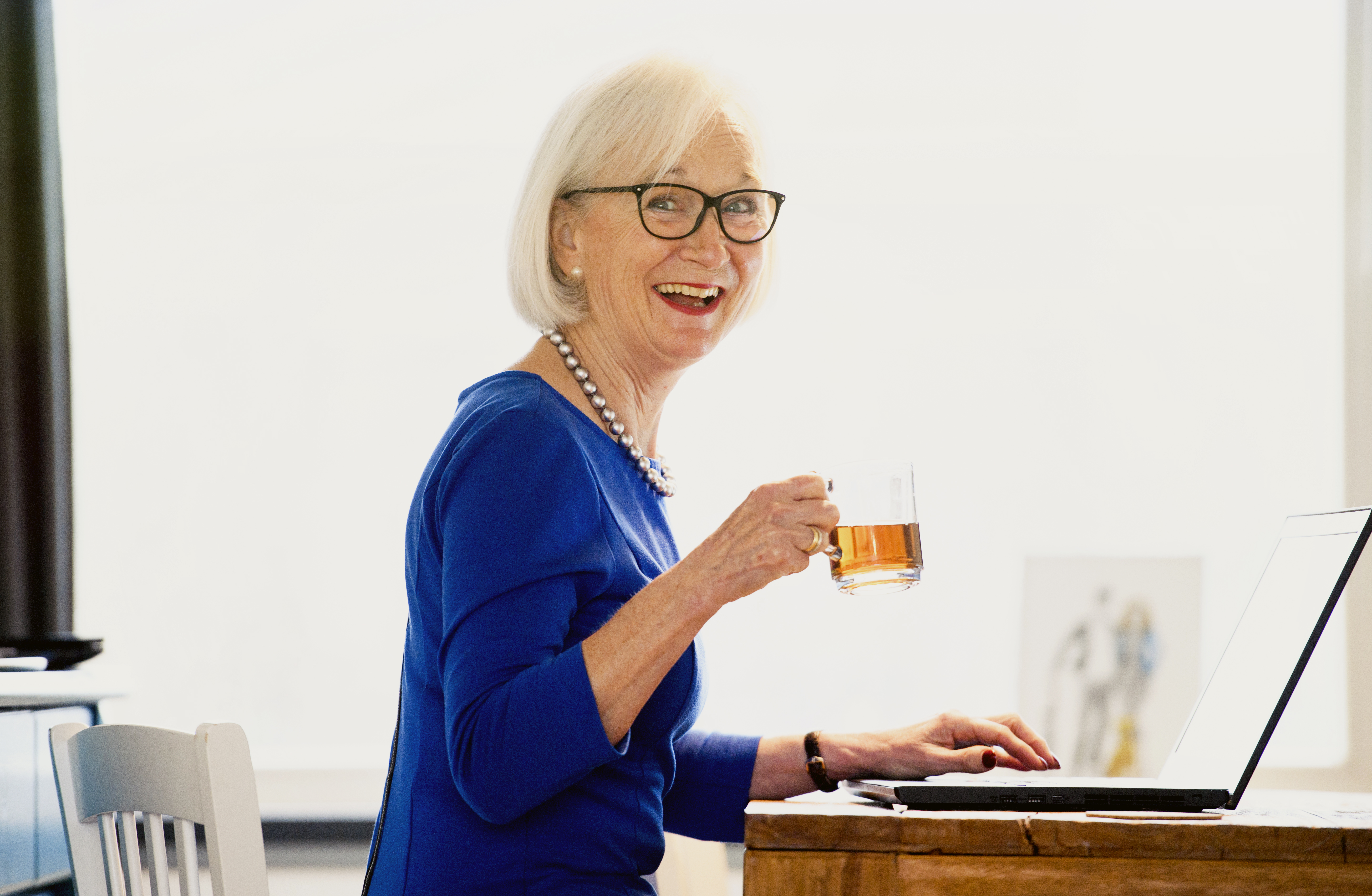 Elderly woman with laptop smiling